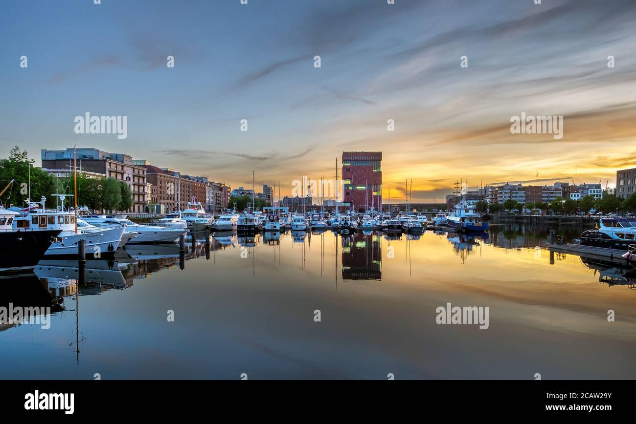 Yachten und das MAS-Museum spiegeln sich im Willem-Dock bei Sonnenuntergang wider. Stockfoto