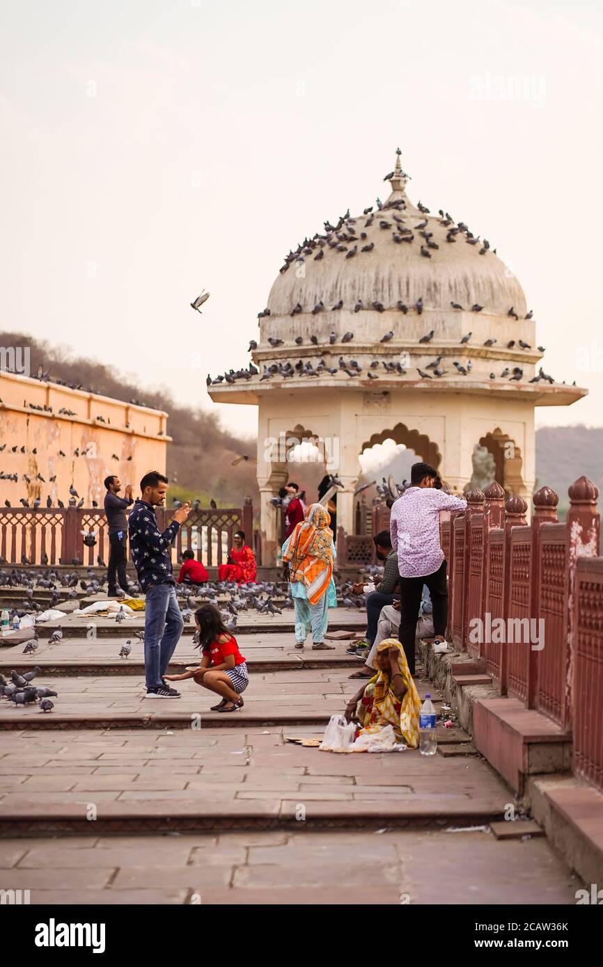 Jaipur / Indien - 27. Februar 2020: Indische Touristen fotografieren vor Jaipur Fort und Frau bettelt für Geld auf dem Boden Stockfoto