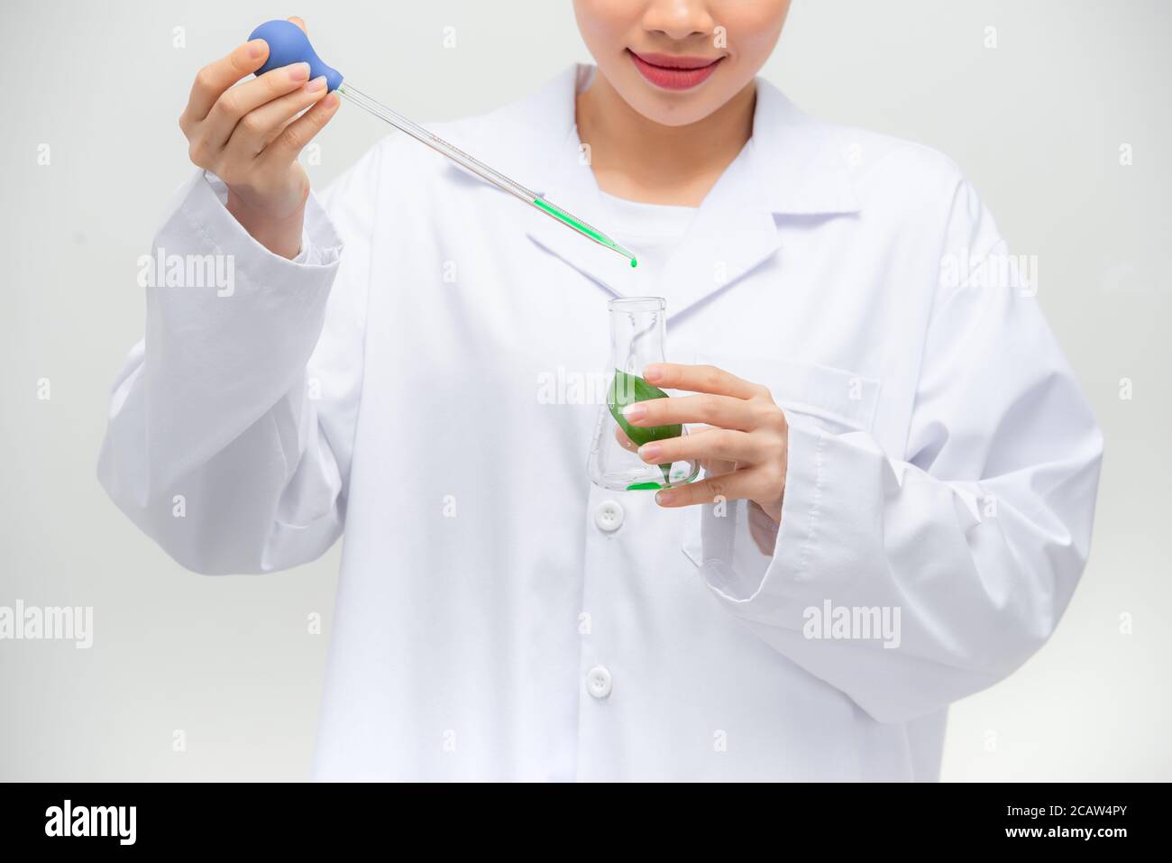 Candid Schuss von schönen jungen asiatischen weiblichen Forscher Durchführung Experiment im Labor, Stockfoto
