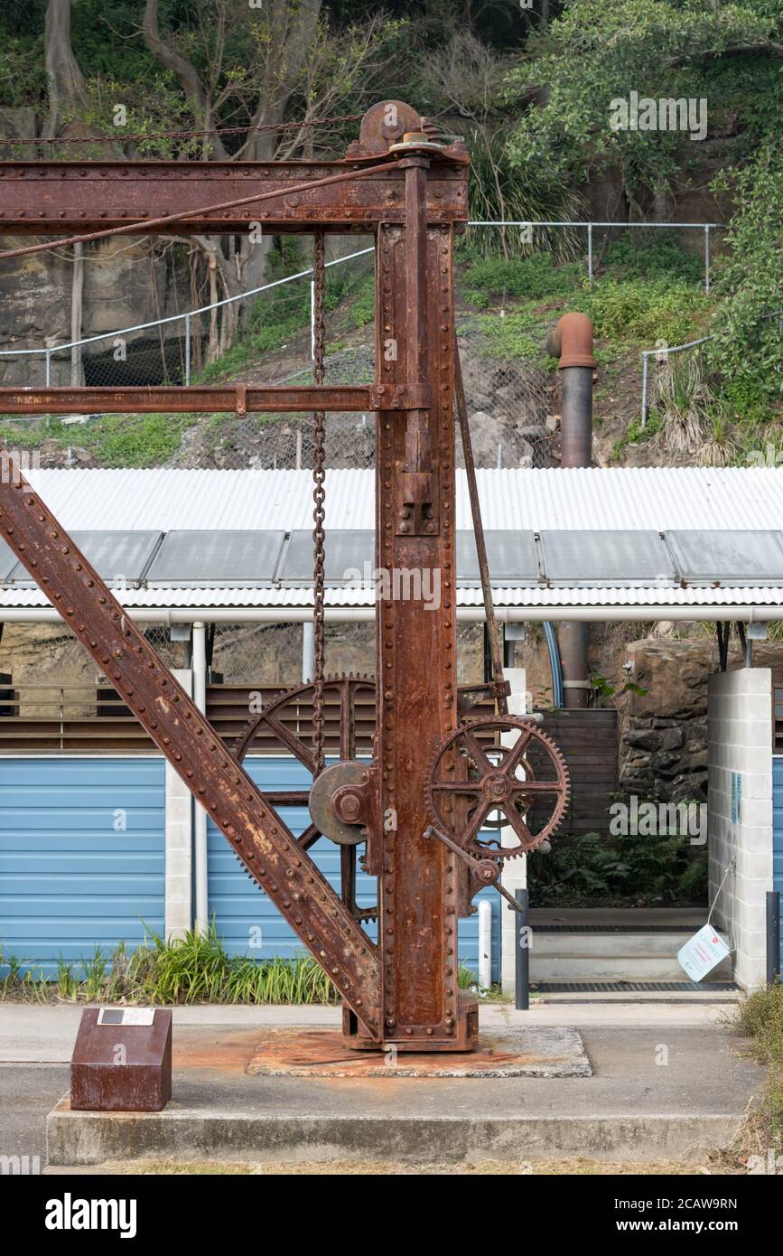 Ein neuer solarbetriebener Dusche- und WC-Waschraum steht im Gegensatz zu einem alten Kran in der Nähe des Campingplatzes auf Cockatoo Island im Sydney Harbour, Australien Stockfoto