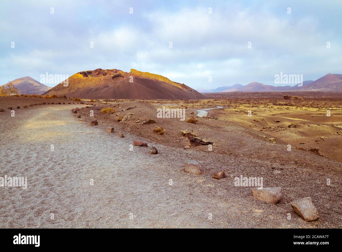 Karge Vulkanlandschaft mit einsamem Pfad am Vulkan El Cuervo ("der Rabe") im Naturpark Los Volcanes auf Lanzarote, Kanarische Inseln, Spanien. Stockfoto