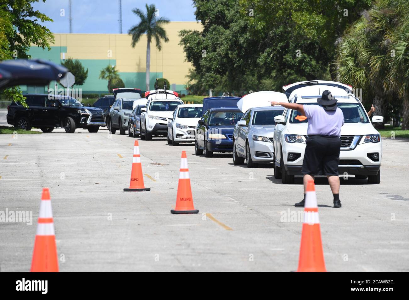 Miami Gardens Beach, FL, USA. August 2020. Ein Freiwilliger wird gesehen, wie er den Verkehr während der Feed Your City Challenge im Calder Casino lenkt, das vom Musikmogul Tony Draper und dem pensionierten NBA-Star Ricky Davis gegründet wurde, Die landesweite Feed Your City Challenge Kampagne liefert frische Lebensmittel und persönliche Schutzausrüstung für benachteiligte Gemeinden, die von der Coronavirus (COVID-19) Pandemie betroffen sind. Am 8. August 2020 in Miami Gardens, Florida. Quelle: Mpi04/Media Punch/Alamy Live News Stockfoto