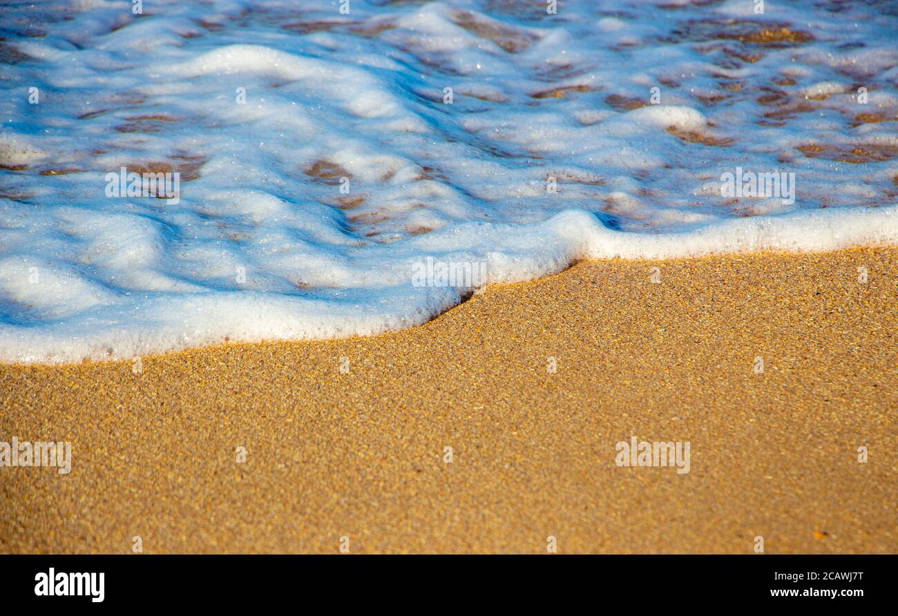Welle und Schaum auf dem Sand, Hintergrund der Wellen auf dem Meer Stockfoto