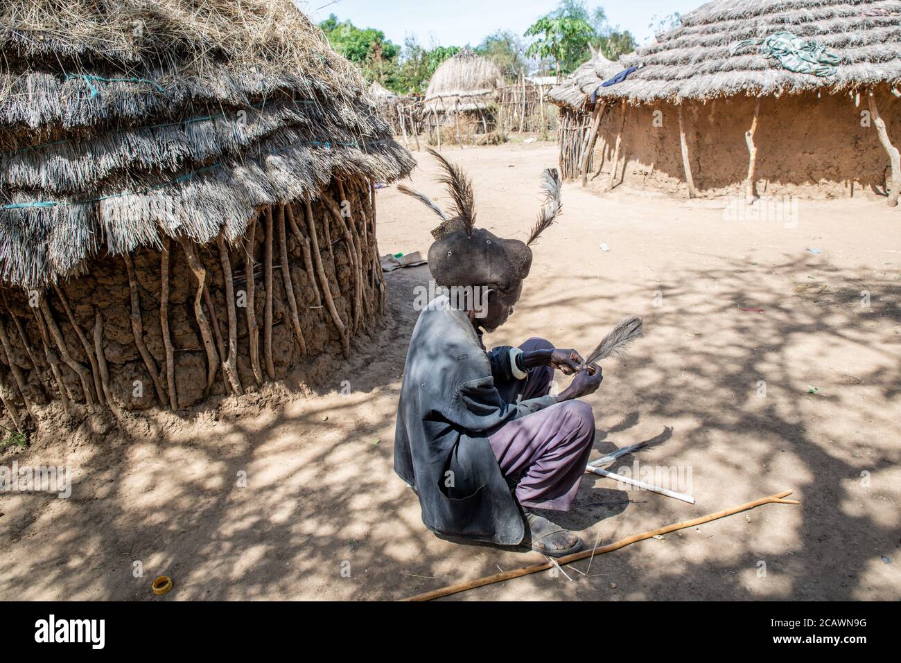 Alter Karamojong-Mann, der eine Etimat (epukot)-Hideaddress aus menschlichem Haar und Straußenfedern aufrechterhält, Moroto District, Uganda Stockfoto