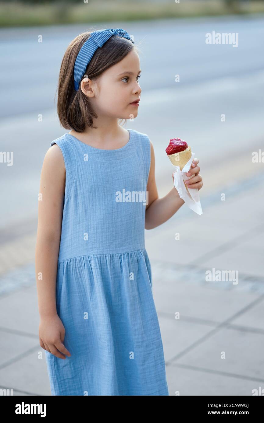 Nettes Mädchen zu Fuß durch die Stadt und essen Eis Stockfoto