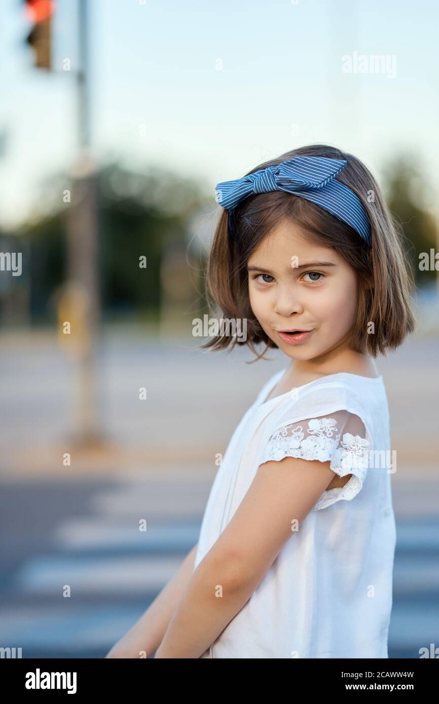 Nettes Mädchen Pose auf der Straße der Stadt bei Sonnenuntergang Stockfoto