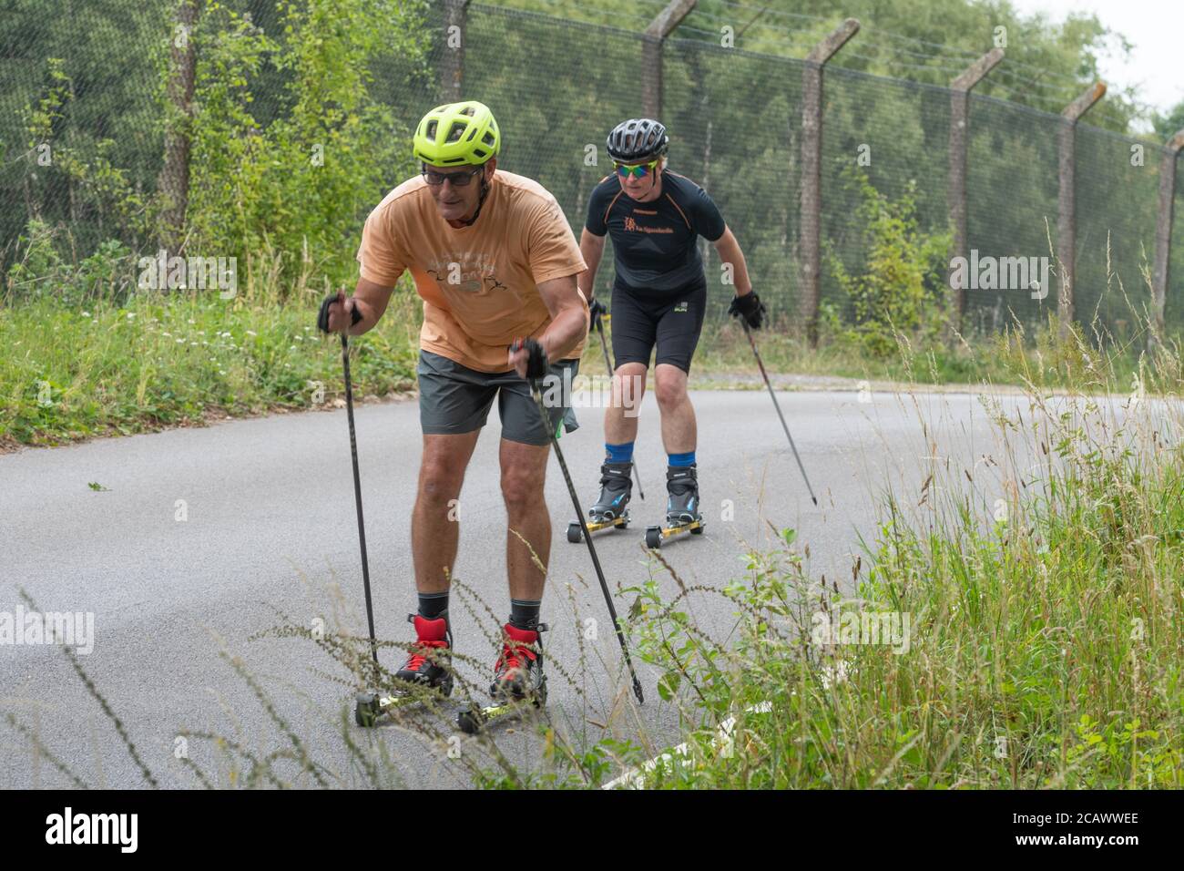 Zwei Männer Rollerski auf einer ruhigen Straße, Aldershot, Großbritannien Stockfoto