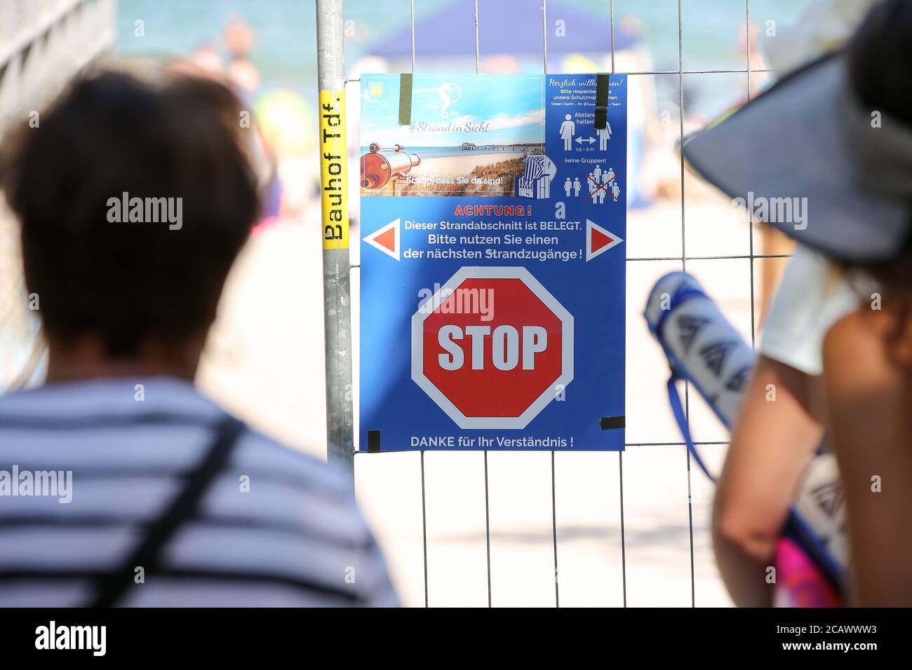 Timmendorfer Strand, Deutschland. August 2020. Badegäste sind an einem geschlossenen Zugang zum Ostseestrand. Ein Stoppschild und die Aufschrift "Achtung - dieser Strandabschnitt ist besetzt - Bitte benutzen Sie einen der nächsten Strandabschnitte! Kredit: Bodo Marks/dpa/Alamy Live Nachrichten Stockfoto