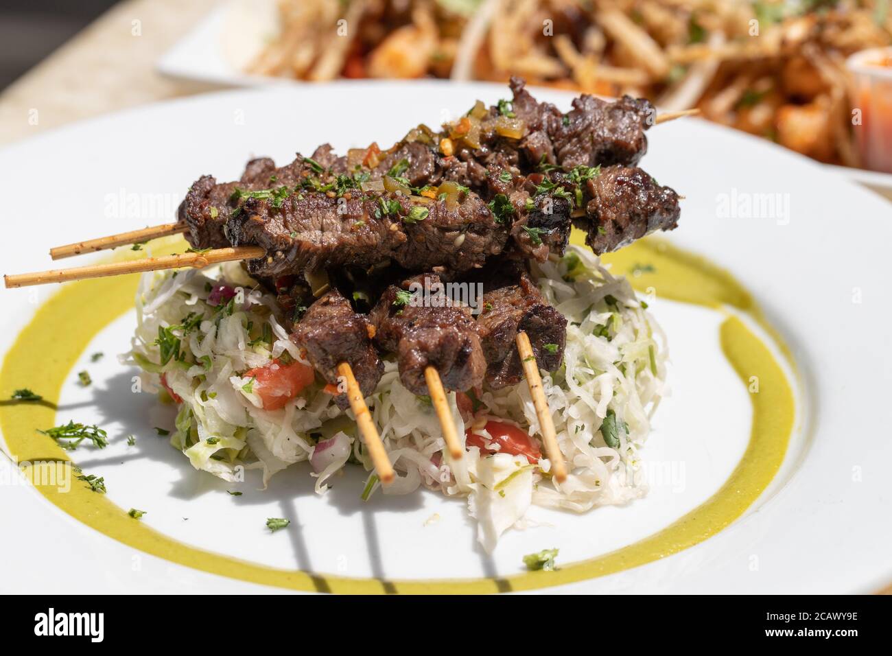 Nahaufnahme von Kohlsalat und Fleischbroschette darauf Stockfoto