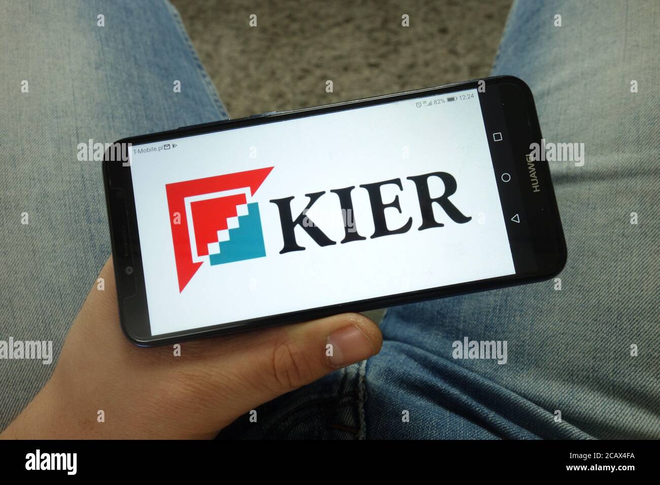 Mann hält Smartphone mit Kier Group plc Logo Stockfoto