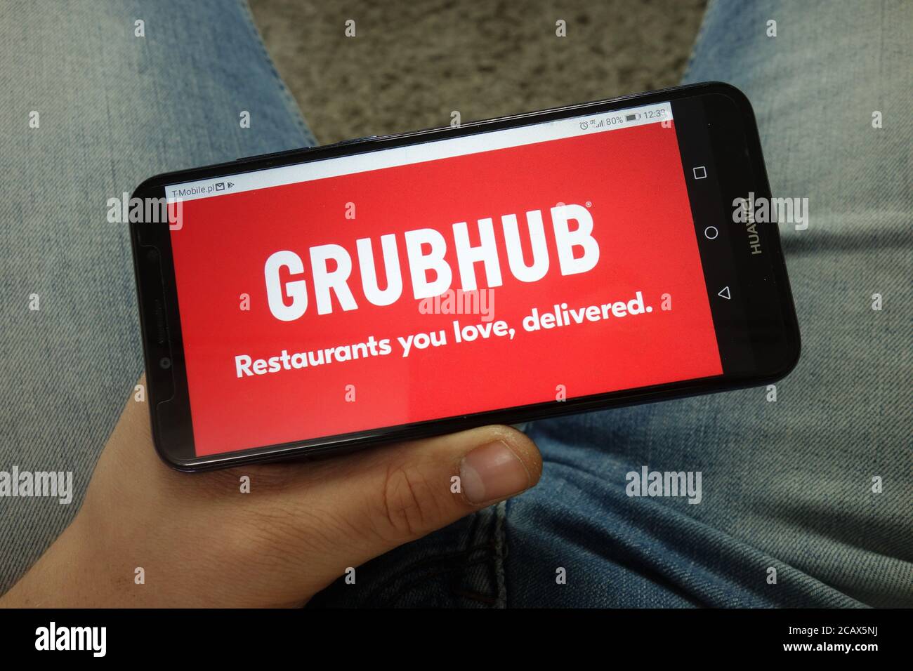 Mann hält Smartphone mit Grubhub Inc. Web-Commerce-Plattform-Logo Stockfoto