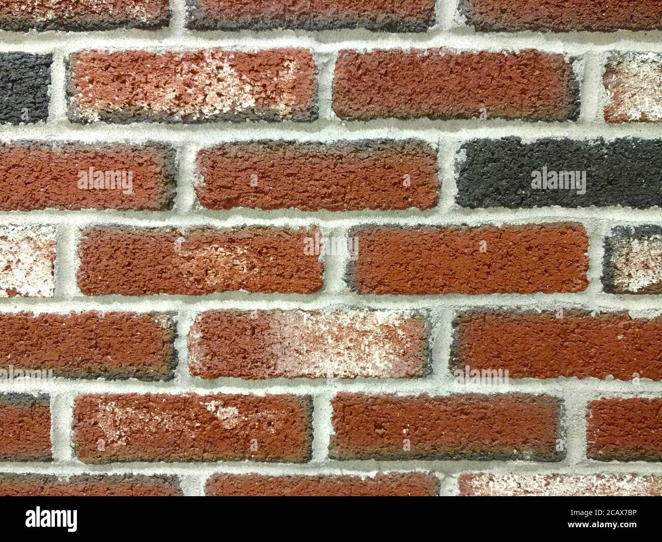 Detaillierte Nahaufnahme alte strukturierte rote schwarze Ziegelwand, satte Farben und Schatten geeignet für Website Hintergrund Marketing Hintergründe Stockfoto