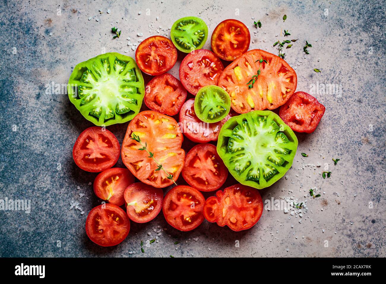 Geschnittene mehrfarbige reife Tomaten auf dunkelblauem Hintergrund, Draufsicht. Stockfoto