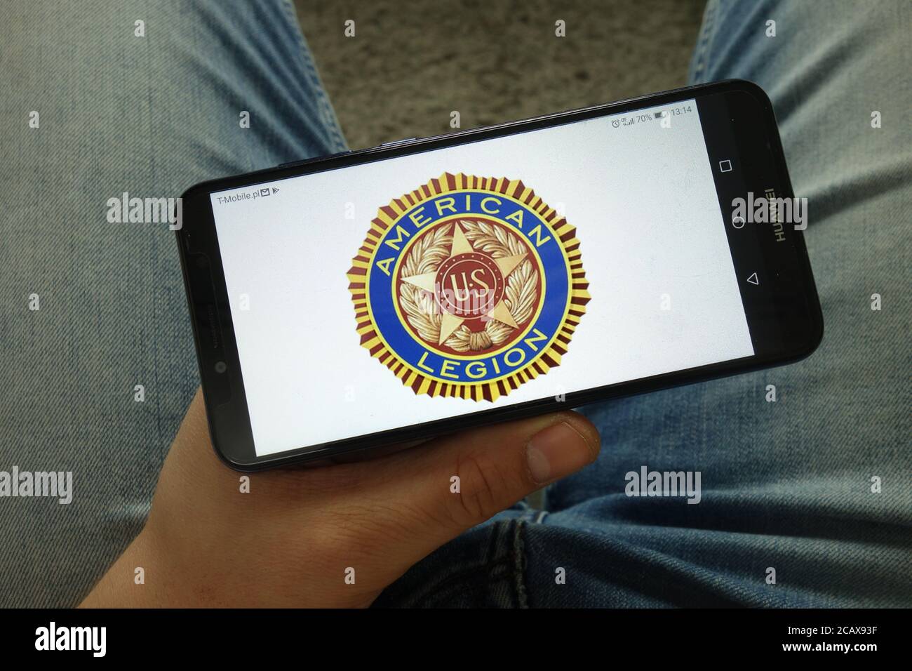 Mann hält Smartphone mit American Legion Organisation Logo Stockfoto