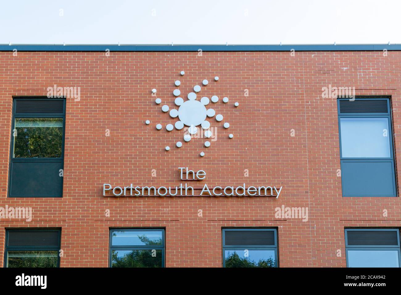 Das Schild auf der Vorderseite der Portsmouth Academy Schule in Portsmouth, UK zeigt das Schullogo Stockfoto