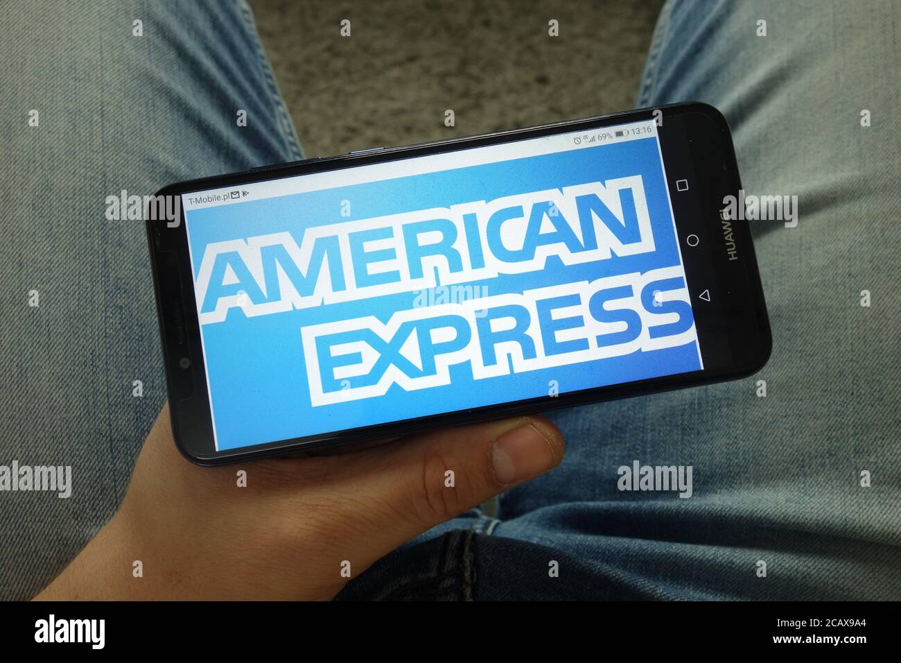 Mann mit Smartphone und American Express Company Logo Stockfoto