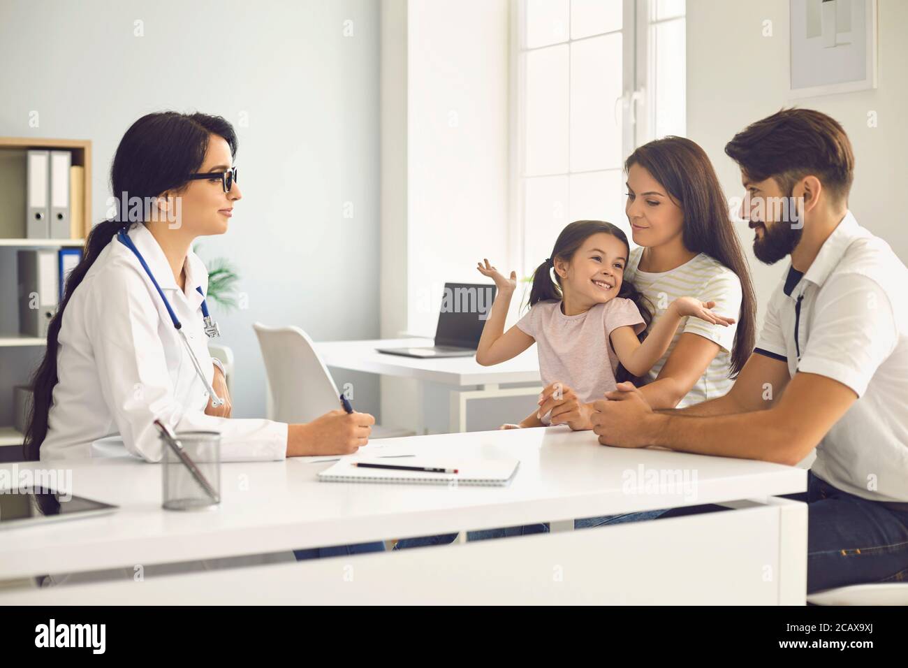 Glückliche Familie bei einer ärztlichen Beratung mit einem Arzt in einer Klinik. Stockfoto