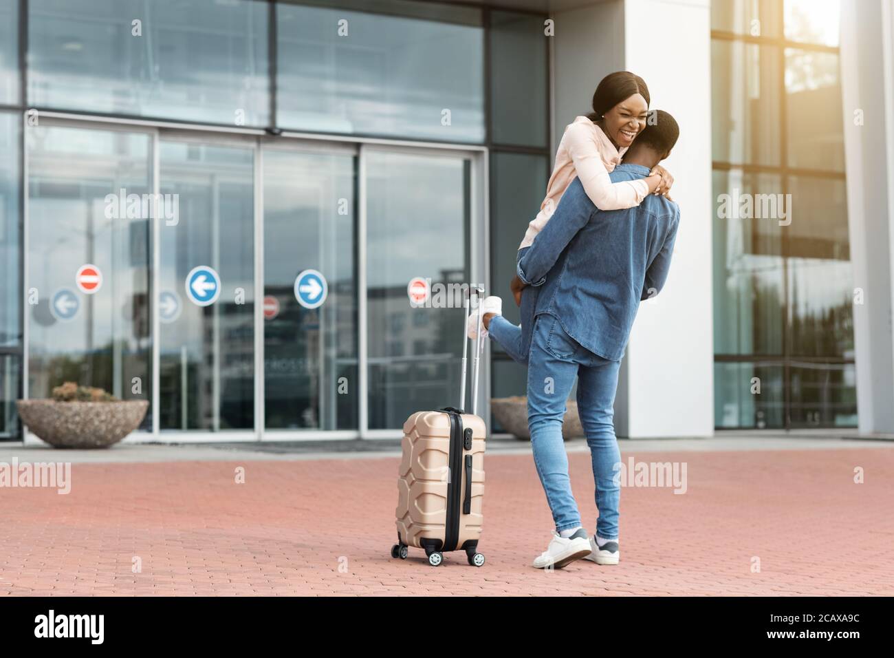 Familientreffen. Glückliches Schwarzes Paar Treffen Am Flughafen Nach Der Ankunft Stockfoto