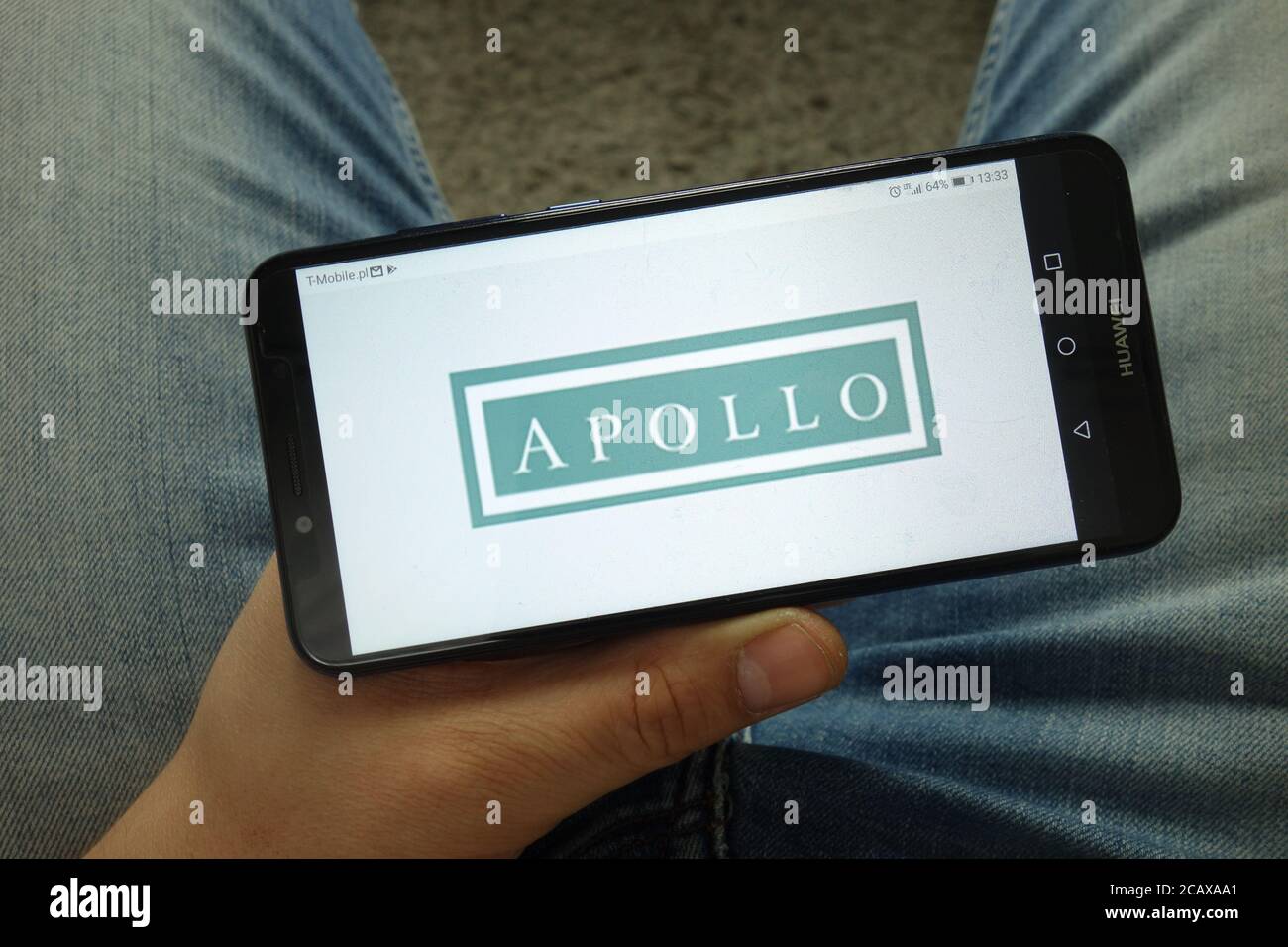 Mann hält Smartphone mit Apollo Global Management, LLC Logo Stockfoto