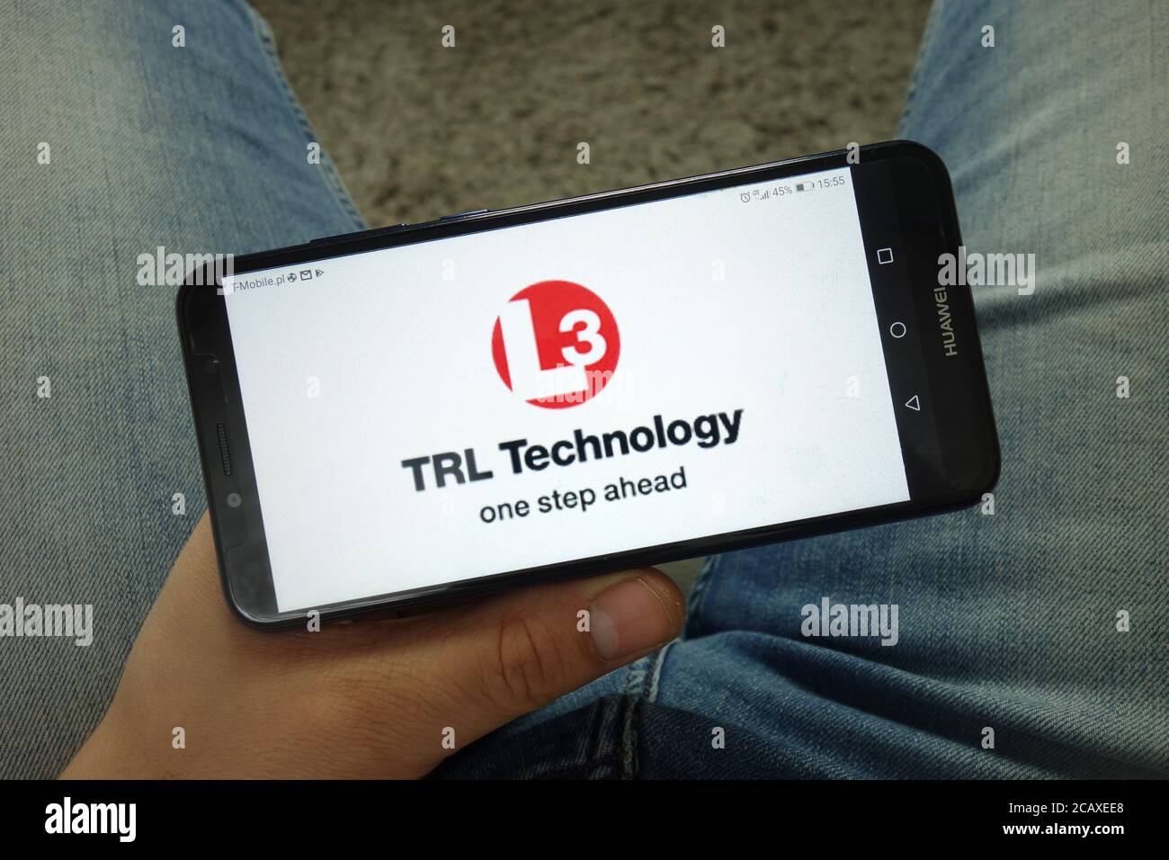 Mann hält Smartphone mit L3 TRL Technology Firmenlogo Stockfoto