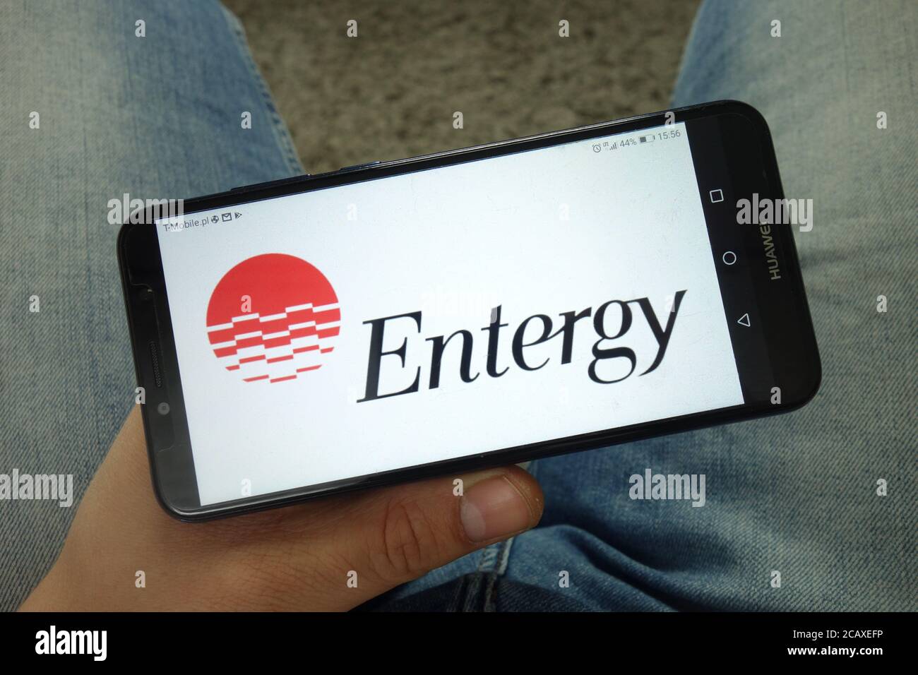 Mann hält Smartphone mit Entergy Corporation Logo Stockfoto