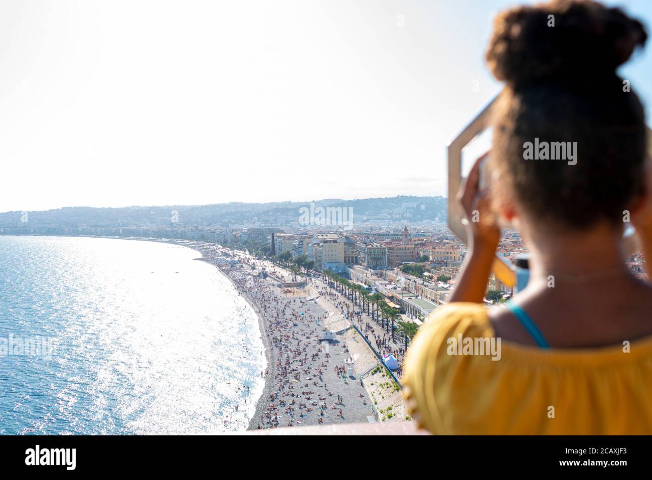 Das Kind schaut durch ein Münzfernglas in der Bucht der Engel in Nizza, Frankreich Stockfoto