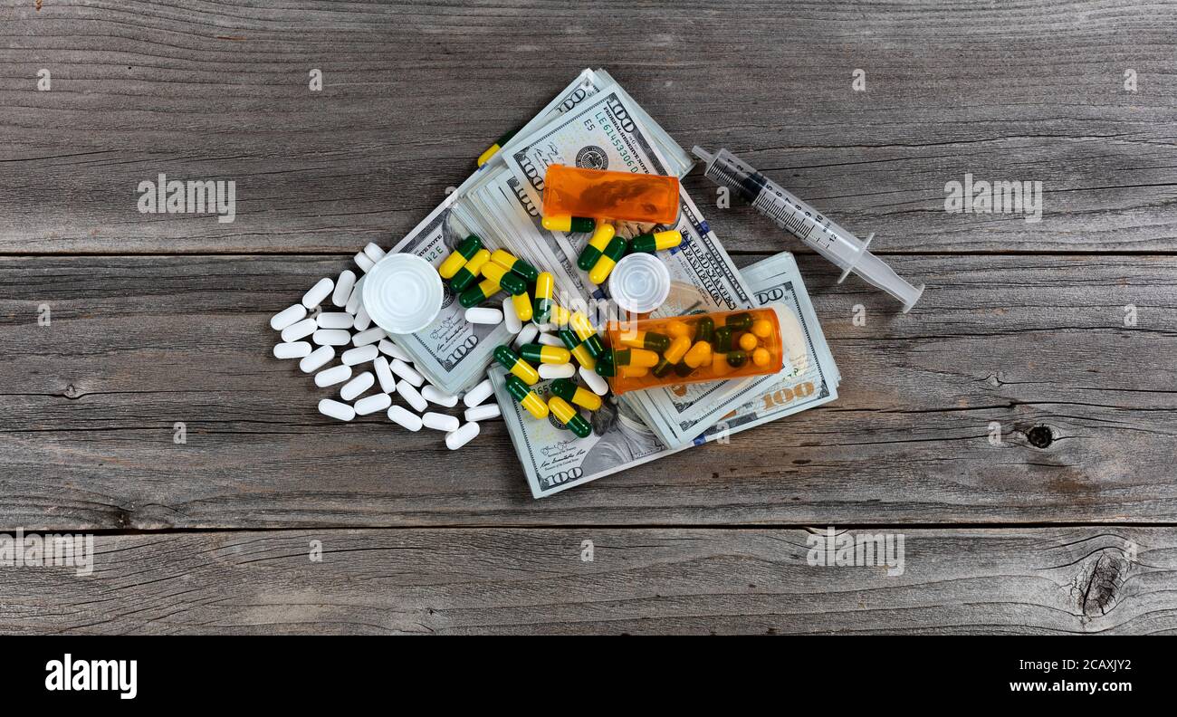 Droge Business-Konzept mit offenen Pillenflaschen auf dem Geldstapel Stockfoto