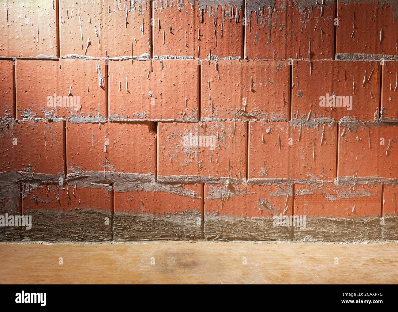 Wand aus Porotherm-Stil Lehmziegel in einem Gebäude im Bau, Hintergrund mit Kopierraum, seitlich beleuchtet Stockfoto