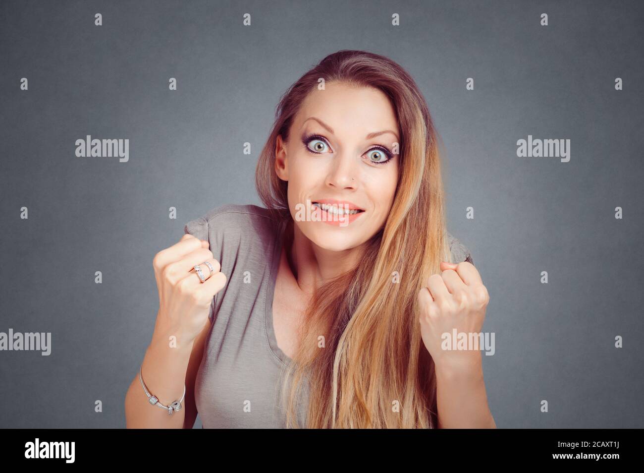 Frau betäubt pumpen Fäuste ballte die Hände in Erwartung über eine Lotterie oder etwas auf Grau studio Wand Hintergrund mit Kopie Raum isoliert zu gewinnen. Stockfoto