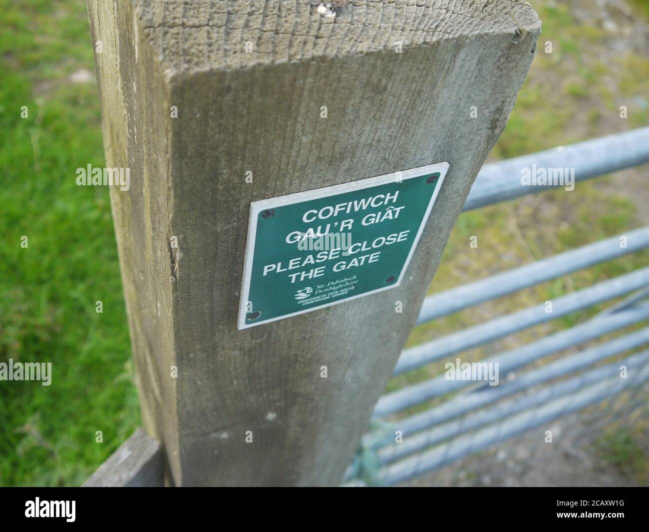 Kleines grünes Schild an einem hölzernen Zaunpfosten befestigt Stockfoto