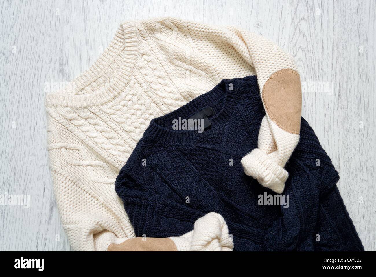 Zwei warme Strickpullover auf Holzgrund. Modisches Konzept Stockfoto