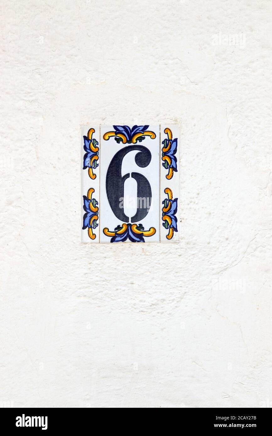 Nummer sechs Hausnummer auf einer Porzellanfliese an einer weißen Wand Stockfoto