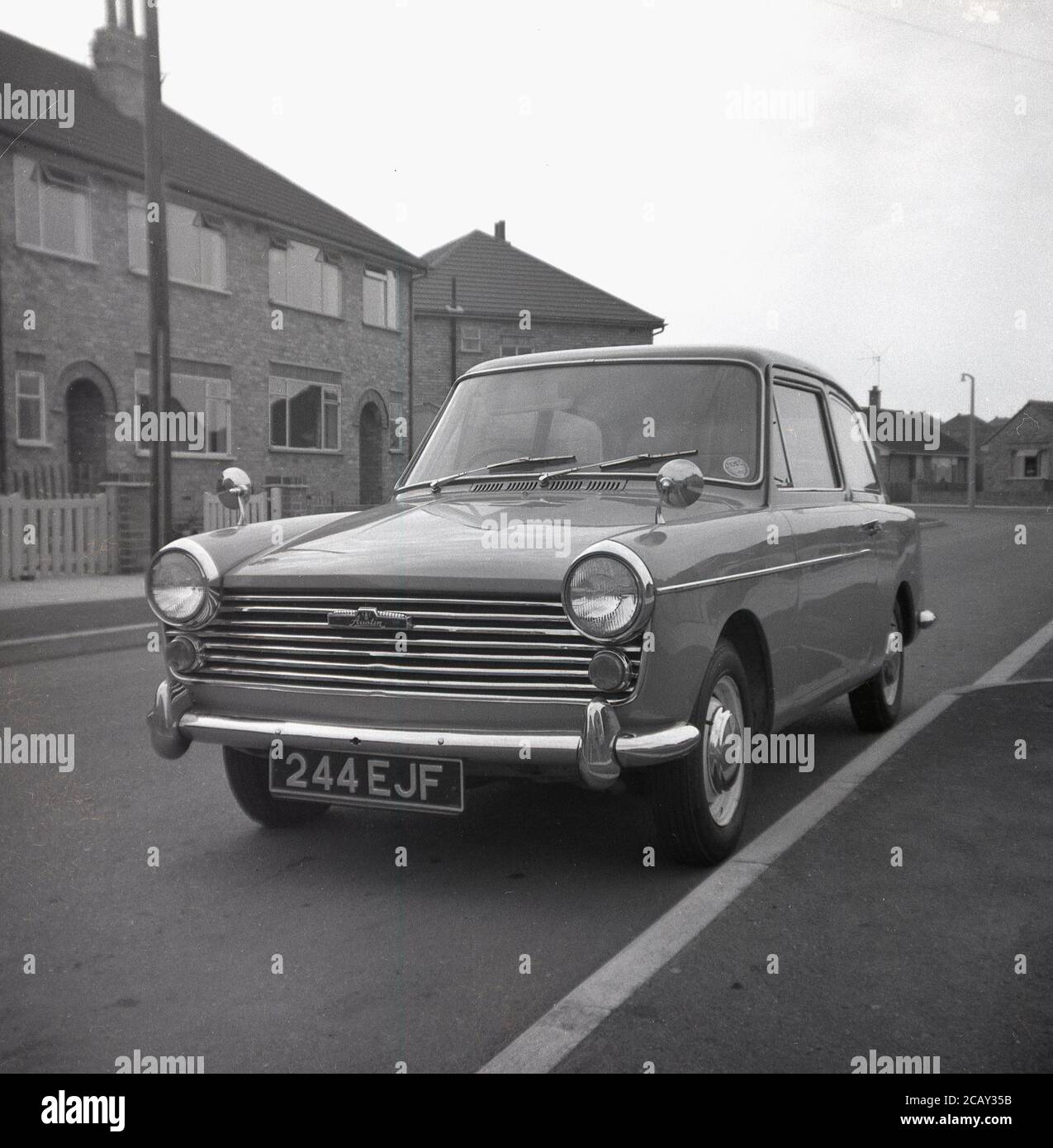 1960, historisch, ein Austin A40 Farina Auto geparkt in einer Straße auf einem neuen Wohngebiet, England, Großbritannien. Ein kleines, sparendes Auto, hergestellt von der britischen Motor Coporation (BMC) wurde es den Namen Austin A40 Farina, was das neue Design des italienischen 'Battista Farina Pinin Farina Turin Studio widerspiegelt. Das hier gezeigte Auto ist die Mark 1 Limousine, die zwischen 1958 und 1961 gebaut wurde. Stockfoto