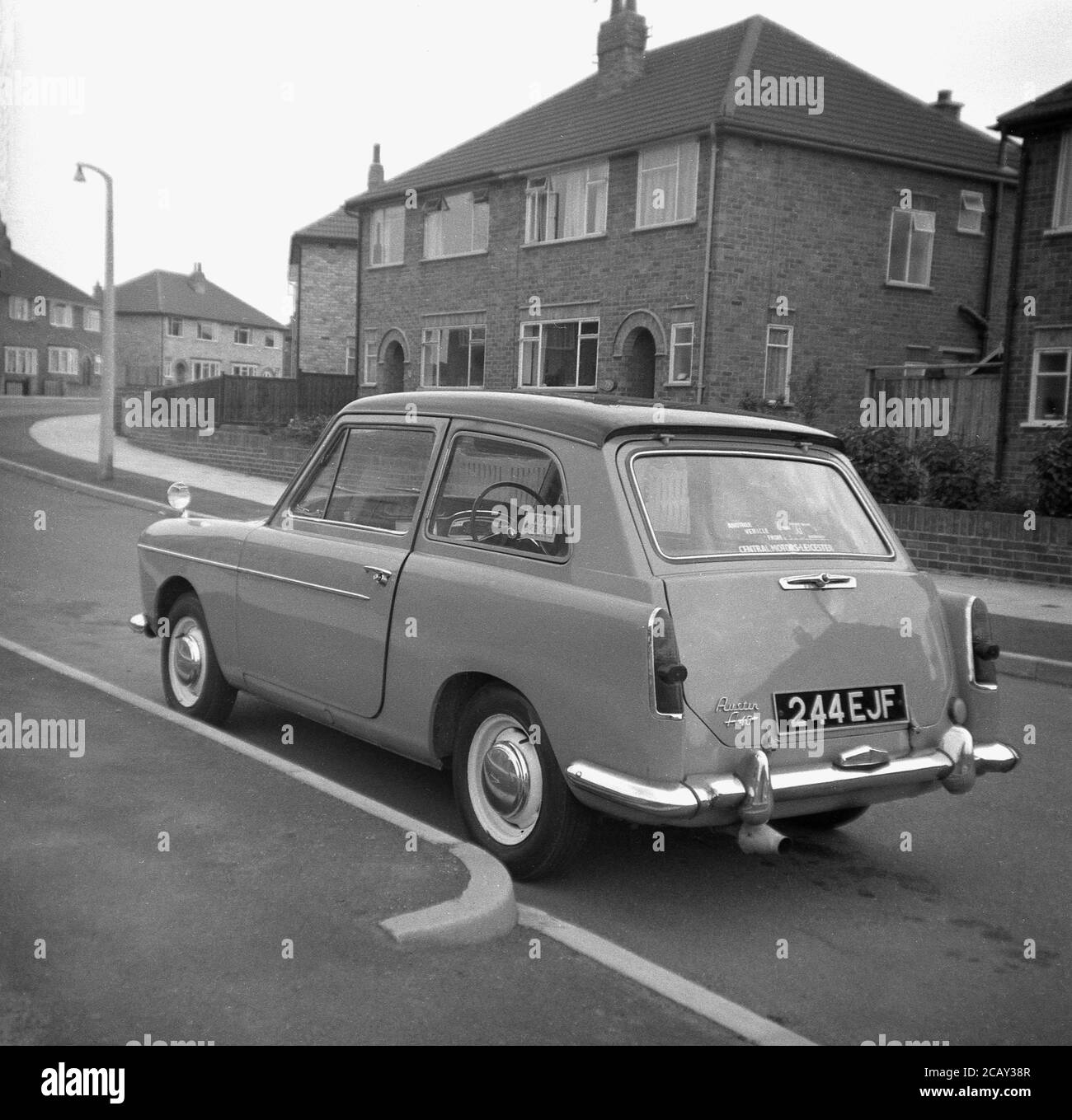 1960, historisch, ein Austin A40 Farina Auto geparkt in einer Straße auf einem neuen Wohngebiet, England, Großbritannien. Ein kleines, sparendes Auto, hergestellt von der britischen Motor Coporation (BMC) wurde es den Namen Austin A40 Farina, was das neue Design des italienischen 'Battista Farina Pinin Farina Turin Studio widerspiegelt. Das hier gezeigte Auto ist die Mark 1 Limousine, die zwischen 1958 und 1961 gebaut wurde. Stockfoto