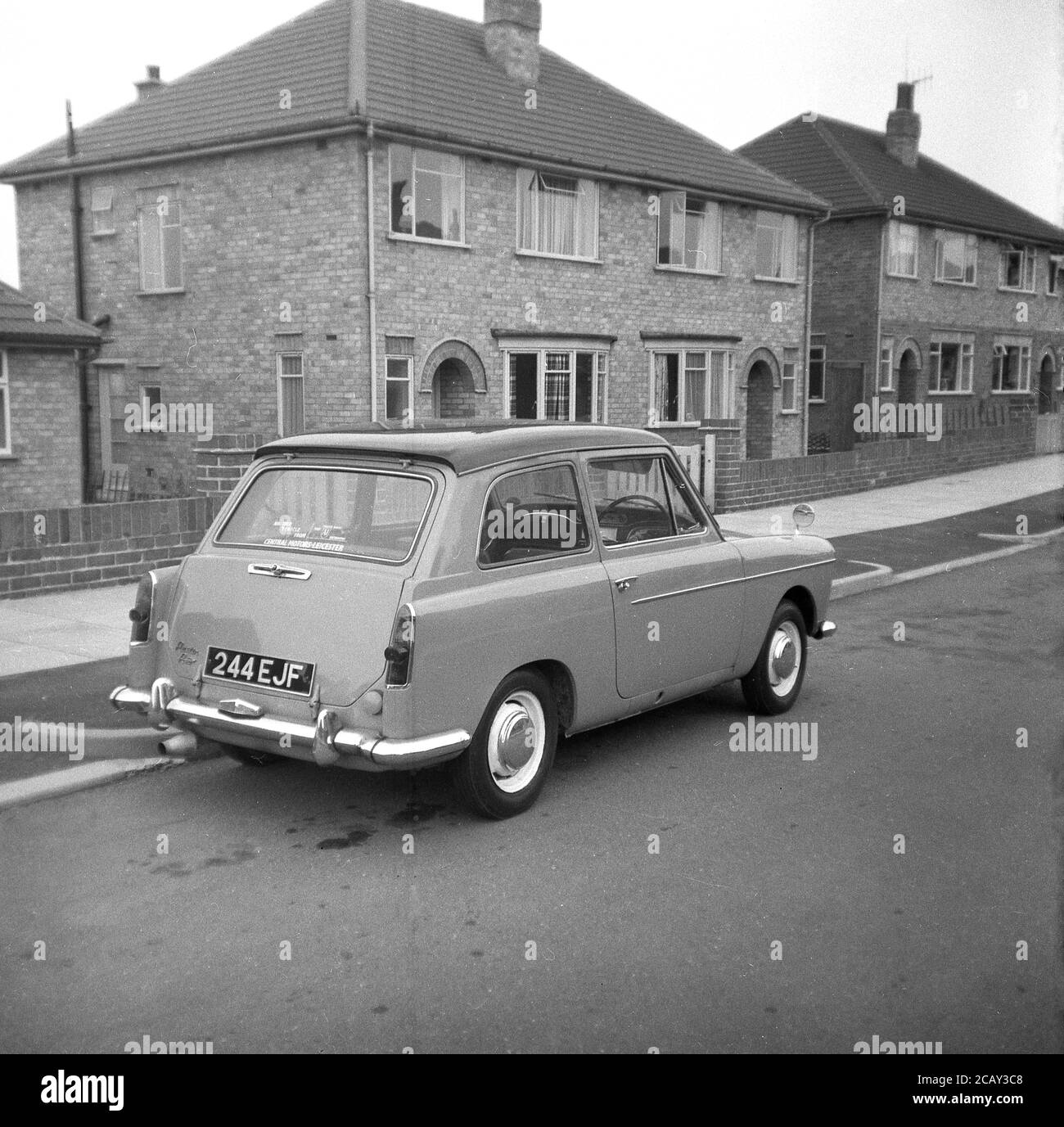 1960, historisch, ein Austin A40 Farina Auto geparkt in einer Straße auf einem neuen Wohngebiet, England, Großbritannien. Ein kleines, sparendes Auto, hergestellt von der britischen Motor Coporation (BMC) wurde es den Namen Austin A40 Farina, was das neue Design des italienischen 'Battista Farina Pinin Farina Turin Studio widerspiegelt. Das hier gezeigte Auto ist die Mark 1 Limousine, die zwischen 1958 und 1961 gebaut wurde. Stockfoto