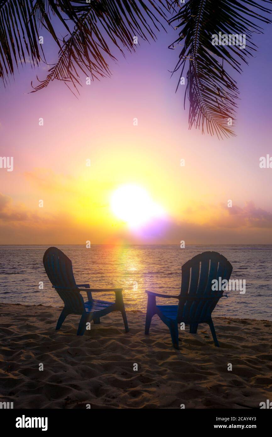 Weicher und traumhafter Sonnenuntergang mit zwei Strandliegen, Grand Cayman Island Stockfoto