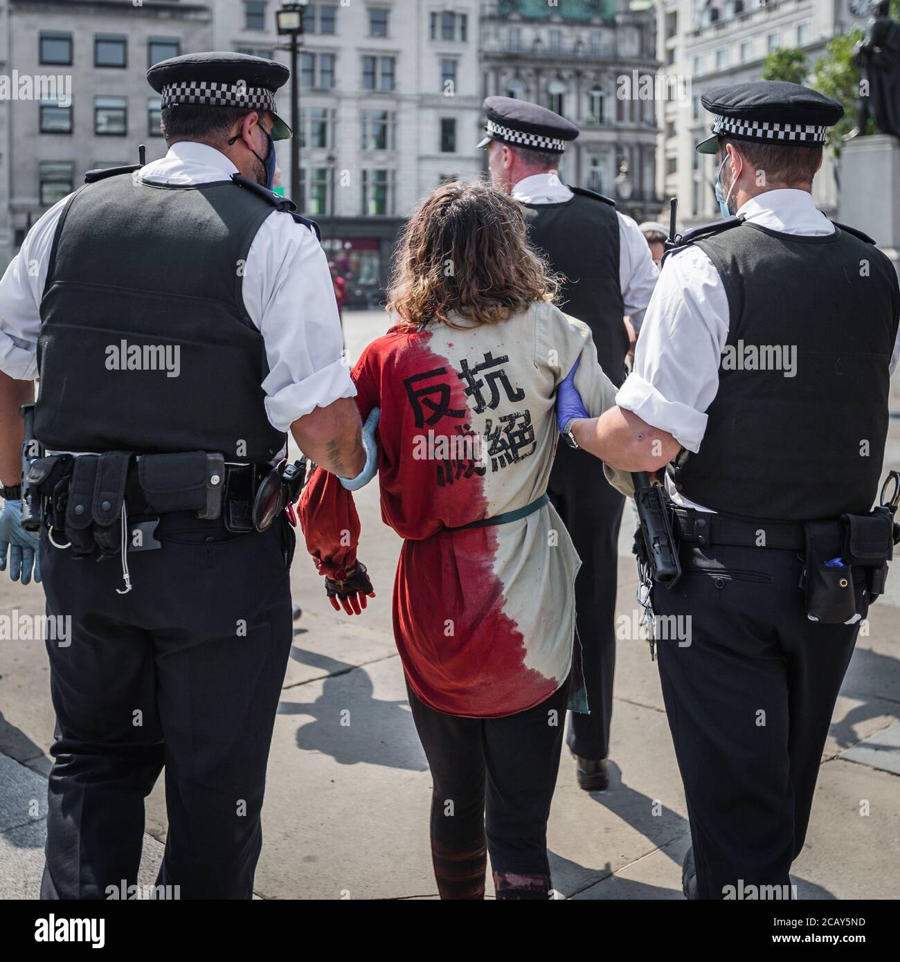 Ein Erlöserproester wird von der Polizei weggeführt Trafalgar Square während eines Protestes gegen den Tod von Indigenen Menschen in Brasilien Stockfoto