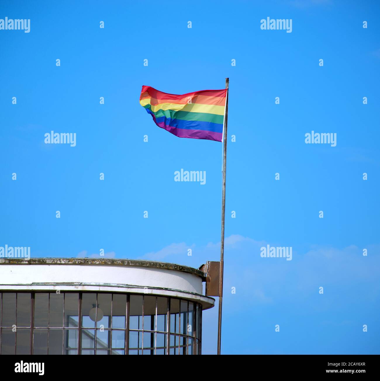 Die Regenbogenfahne, die über dem ikonischen De La Warr Pavillon in Bexhill, Sussex, England, Großbritannien, fliegt. Stockfoto