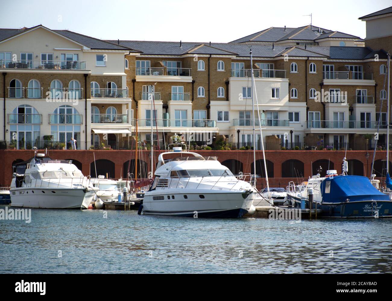 Luxuswohnungen neben festgeschobten Booten in Soverign Harbour, Eastbourne, Sussex, England, Großbritannien. Stockfoto