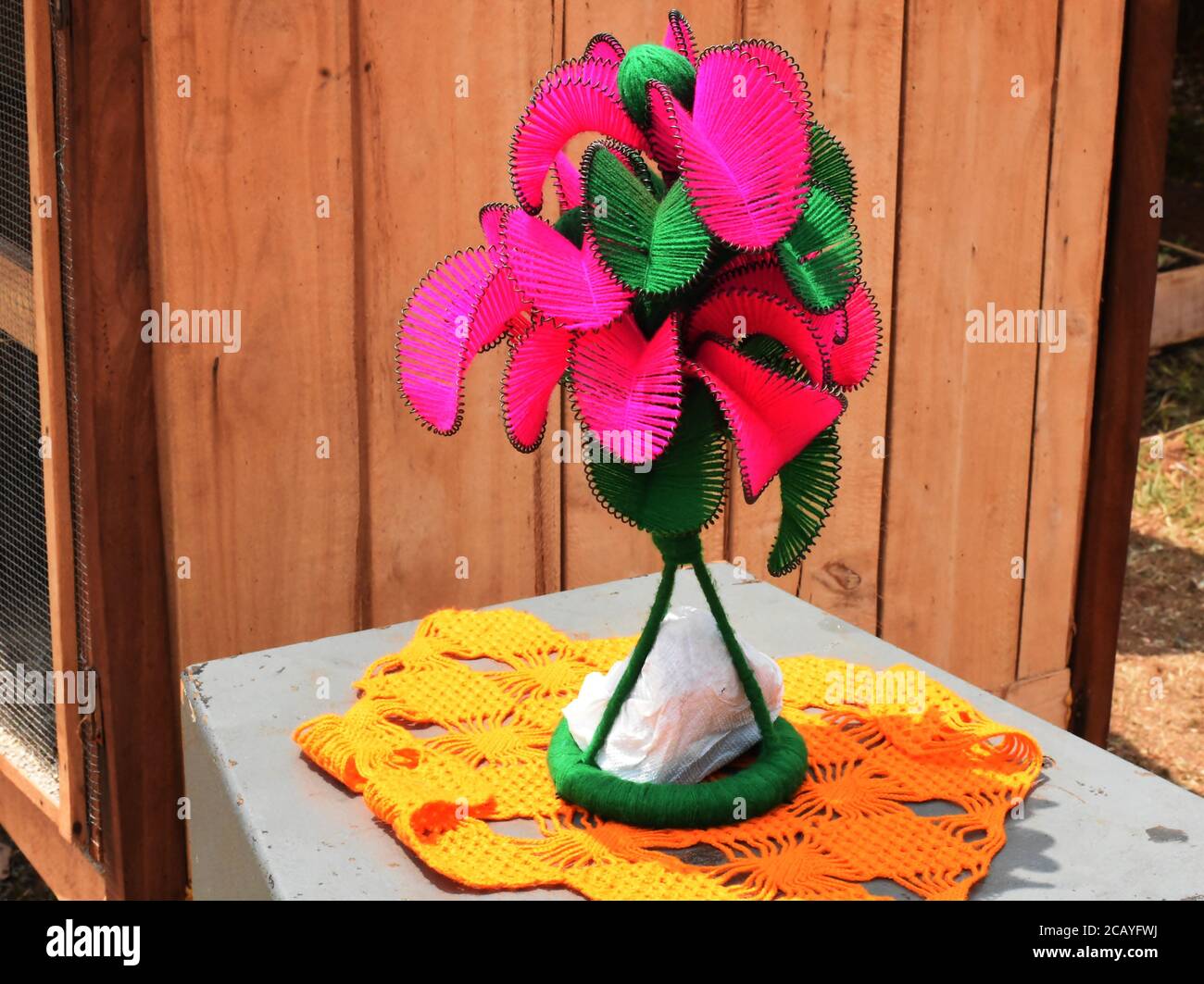 Grüne und rote blättrige Blume in Fäden gemacht Stockfoto