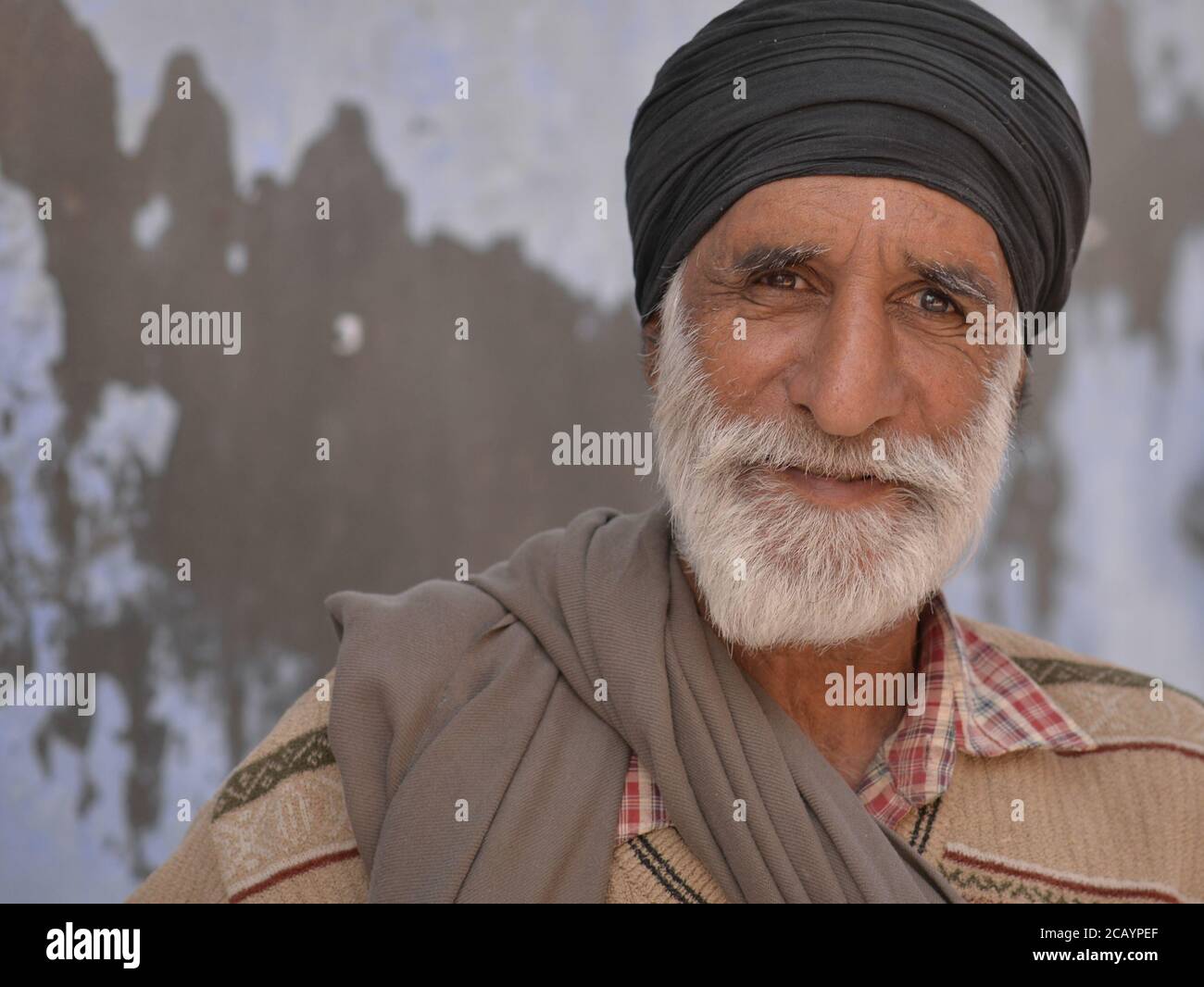 Älterer indischer Sikh-Mann mit schwarzem Turban (dastar) posiert für die Kamera. Stockfoto