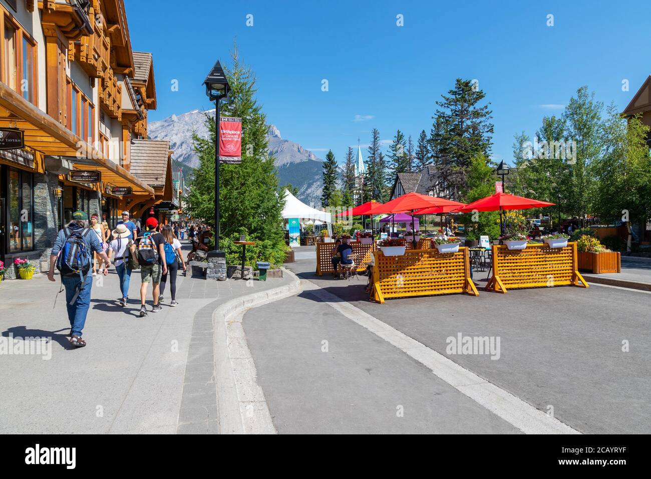 BANFF, KANADA - 29. JULI 2020: Touristen gehen und essen entlang der Banff Avenue im Banff National Park. Die Straße wurde wegen COVID-19 geschlossen, um Mo zu ermöglichen Stockfoto