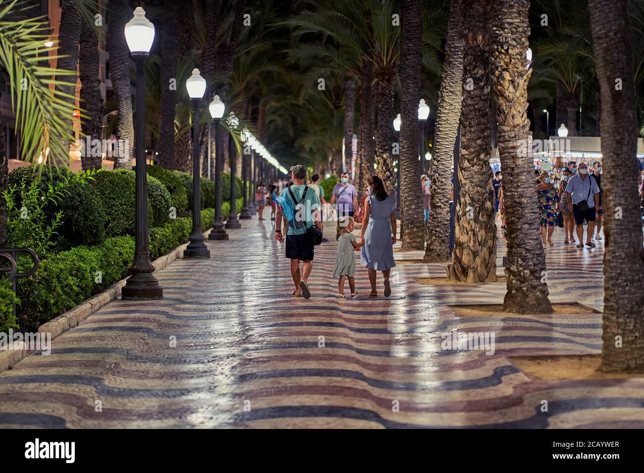 Eltern und ihre kleine Tochter machen einen abendlichen Spaziergang entlang der Promonade in Alicante City, Spanien, Europa, Juli 2020 Stockfoto
