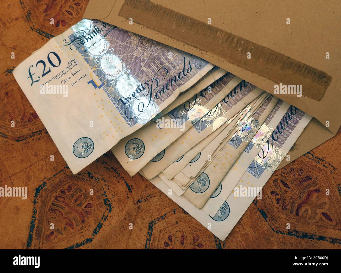 Britische Sterling-Noten in einem braunen Umschlag, fünf Pfund, zehn Pfund, zwanzig Pfund, Note, schwarze Wirtschaft, Zahlung Stockfoto