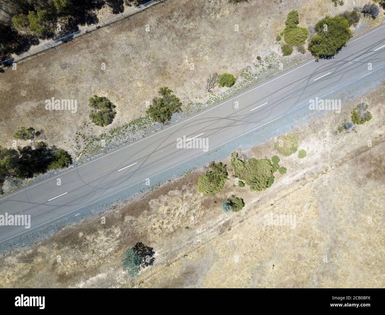 Autoabsperrmarkierung Luftaufnahme auf asphaltierten Straßen mit Grasfeldern und Zaun, Victoria, Australien. Stockfoto