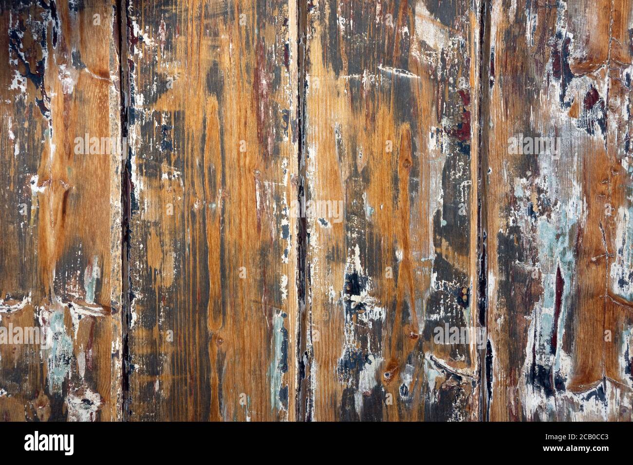Verwitterter Holzhintergrund mit abblätternder Farbstruktur und abstrakten Linienmustern auf einer alten Holztür. Stockfoto