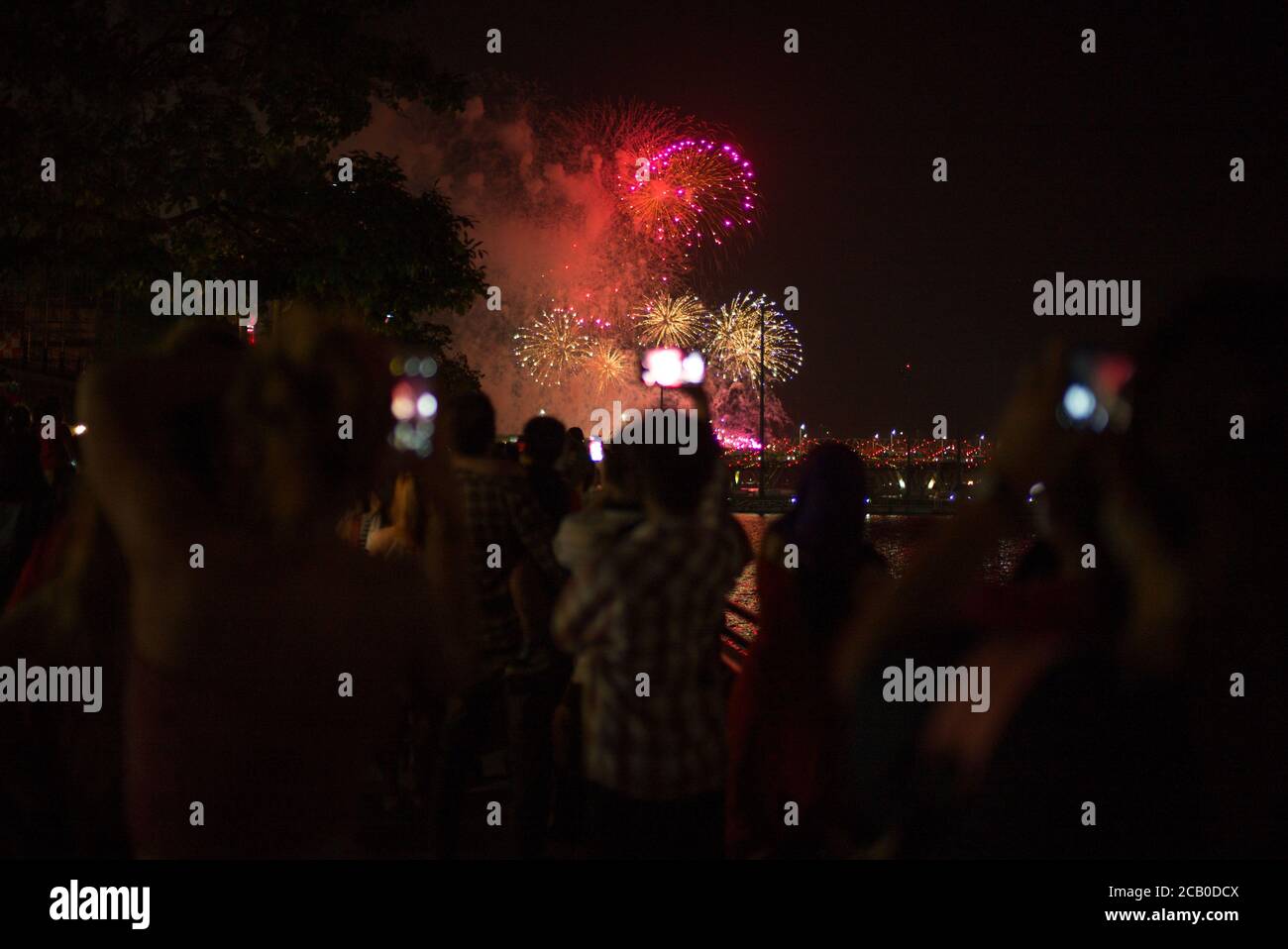 Menschen an der Esplanade-Brücke fotografieren Feuerwerke während des Singapore National Day.Singapur feiert seinen 55. Nationalen Tag am 9. August 2020 inmitten der Covid-19 Pandemie. Stockfoto