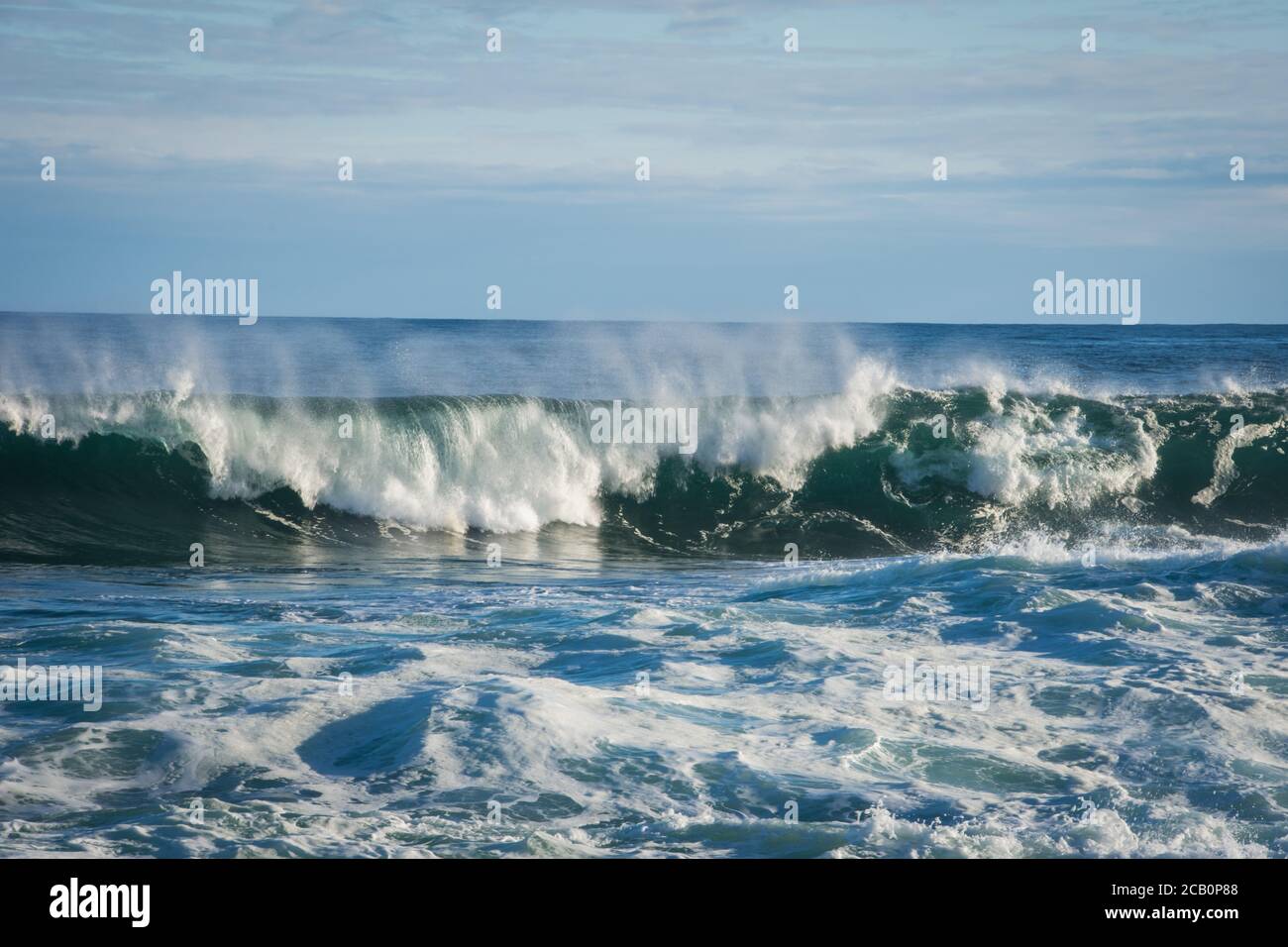 Welle bricht mit weißem Schaum im Wind gesehen geblasen Von der Vorderansicht Stockfoto