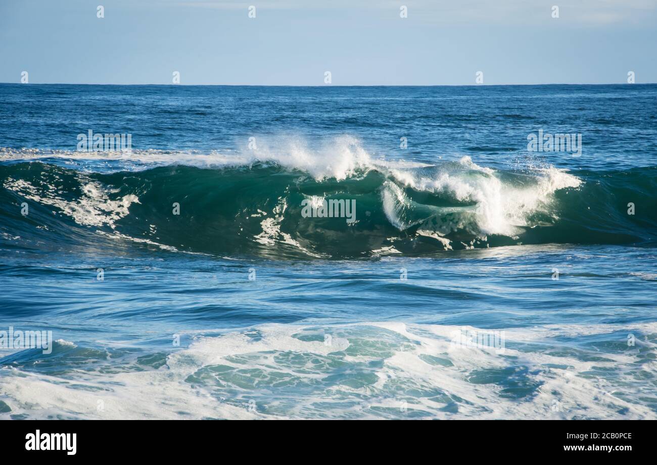 Welle bricht mit weißem Schaum im Wind gesehen geblasen Von der Vorderansicht Stockfoto