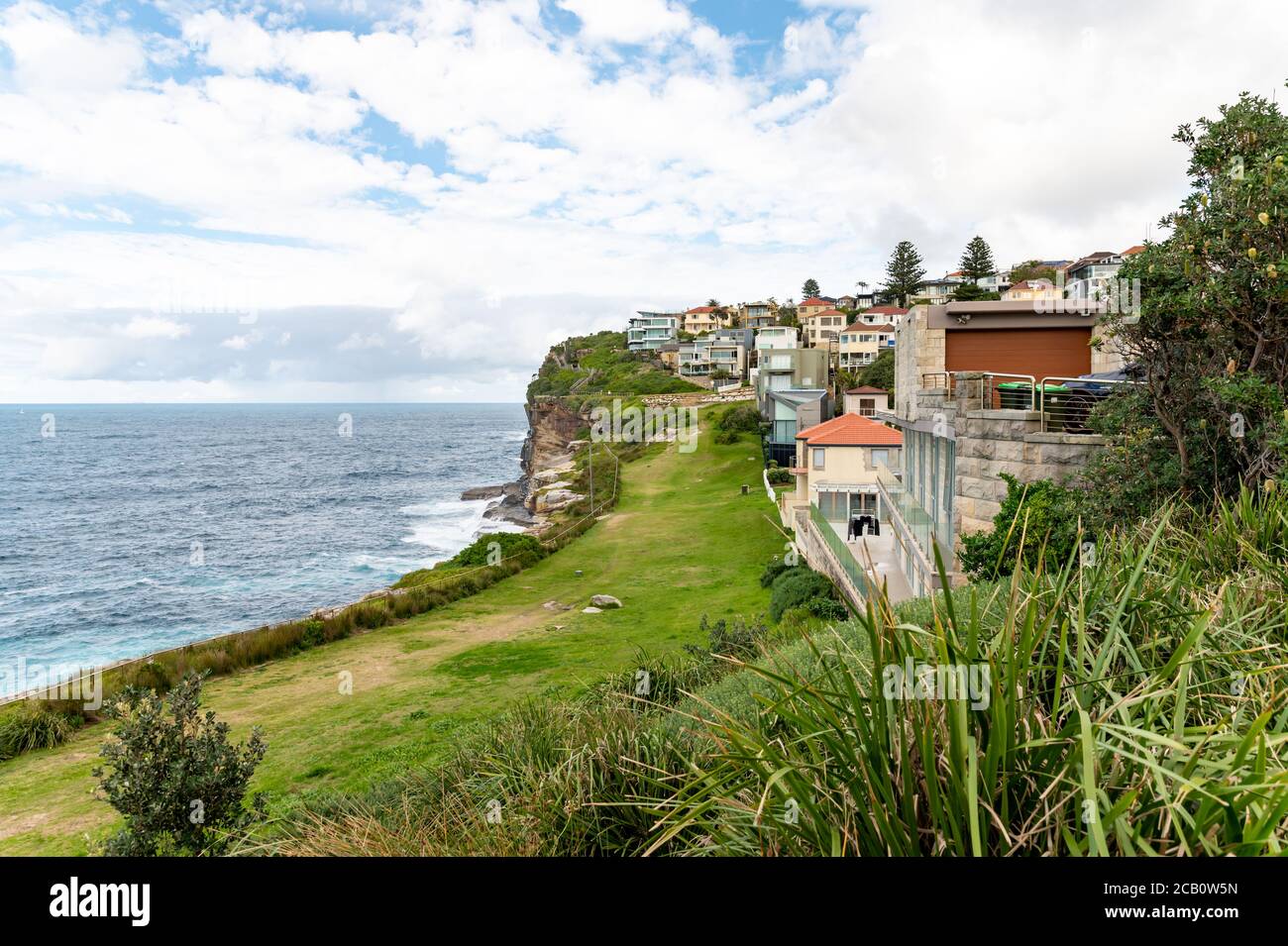 Sydney NSW Australien - 27. Mai 2020 - Big Grass Bereich auf der Klippe in Vaucluse und einige Gebäude und Häuser und der Ozean Hintergrund verschwimmen Stockfoto